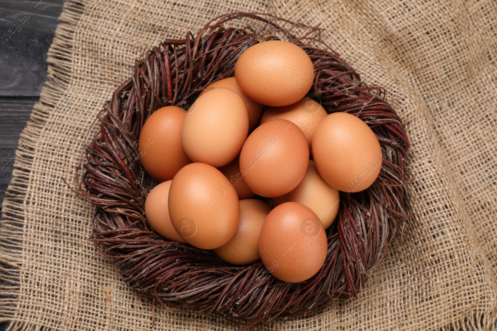 Photo of Fresh chicken eggs in nest on table, top view