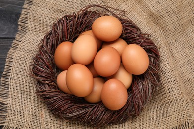 Photo of Fresh chicken eggs in nest on table, top view