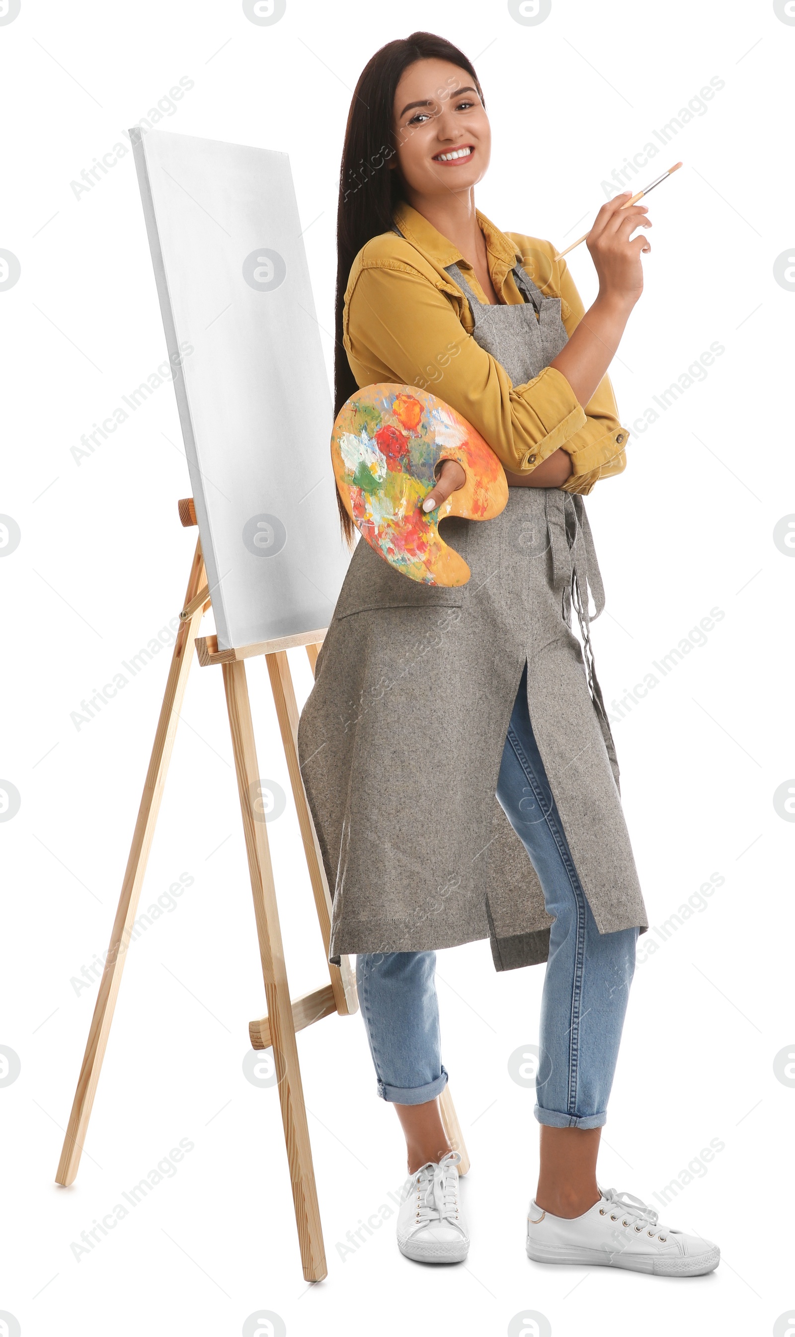 Photo of Young woman with drawing tools near easel on white background