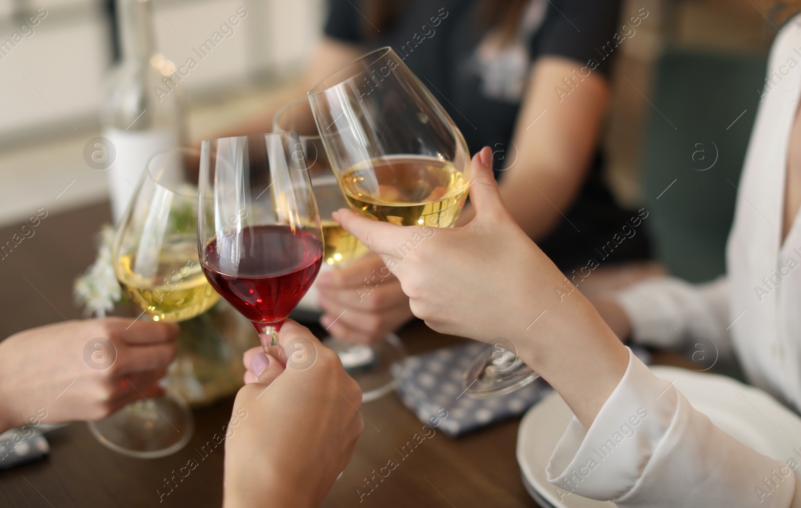 Photo of Young people with glasses of delicious wine at table