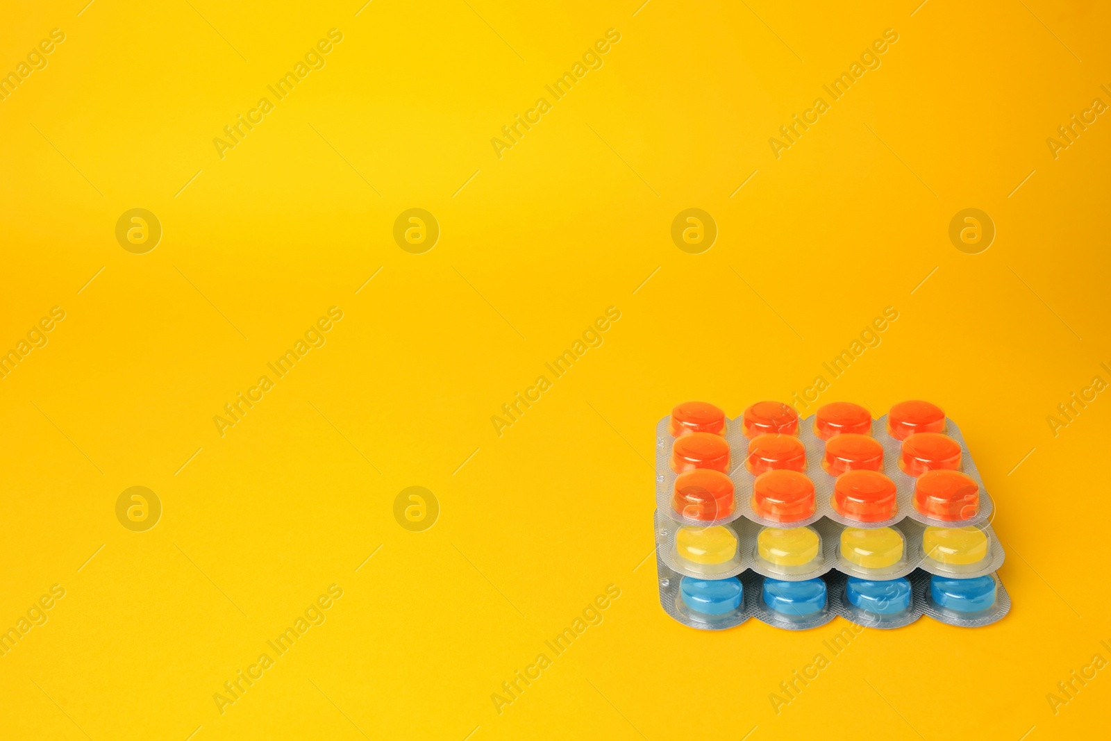 Photo of Blisters with cough drops on yellow background. Space for text