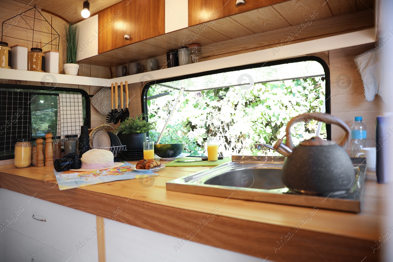 Photo of Stylish kitchen interior with different accessories and utensils in modern trailer. Camping vacation