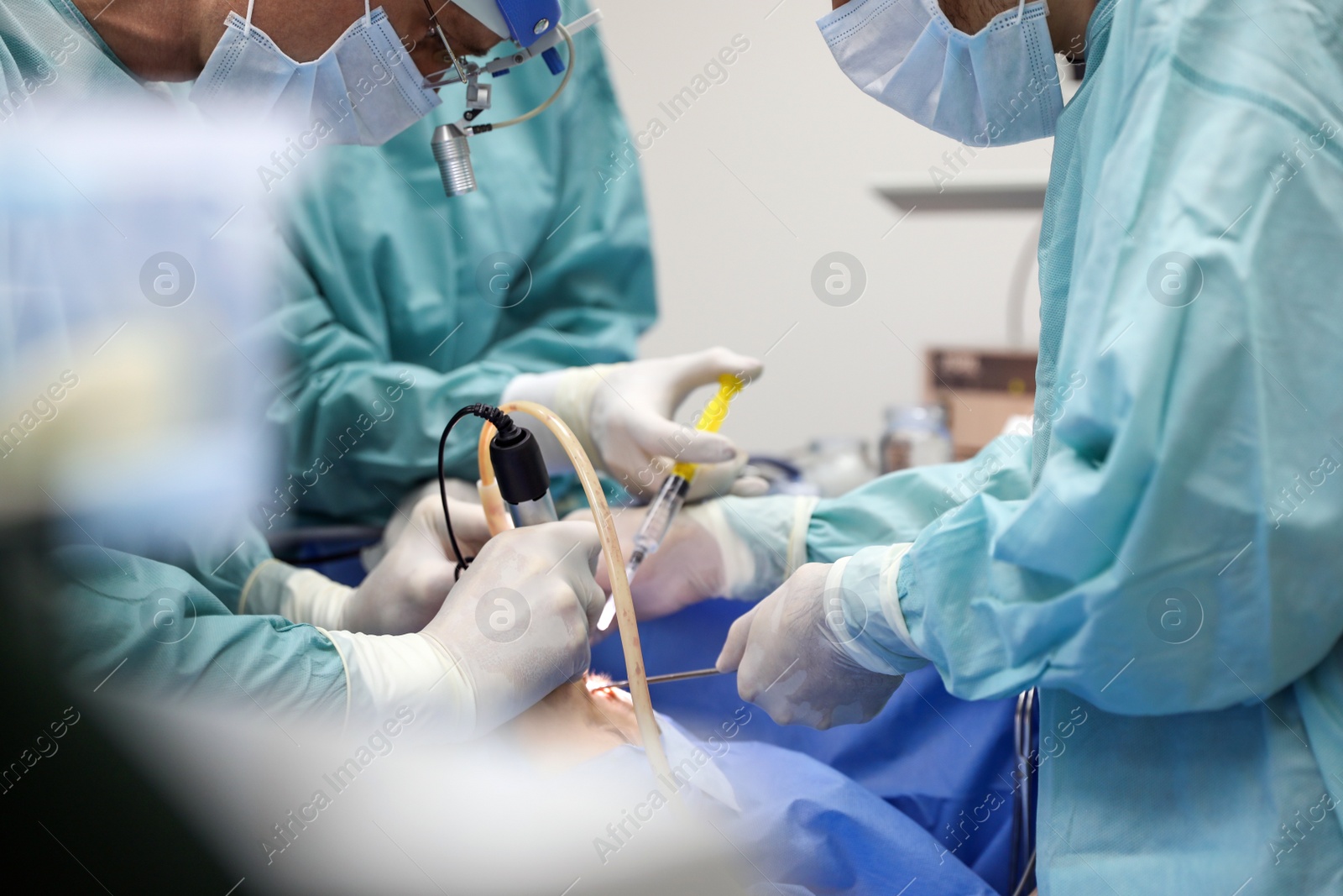 Photo of Professional doctors performing 
frontal sinus trephination in surgery room, closeup