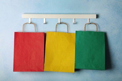 Photo of Rack with paper shopping bags on color wall