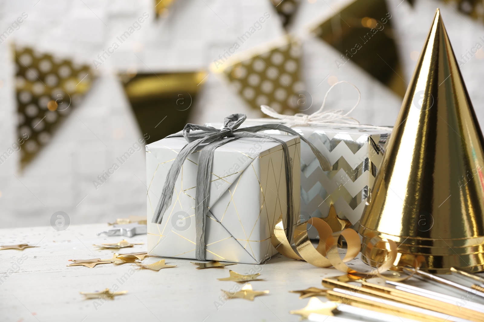 Photo of Gifts and party cones on table against blurred background