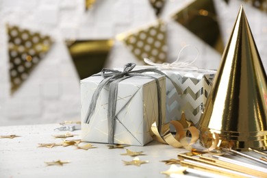 Photo of Gifts and party cones on table against blurred background