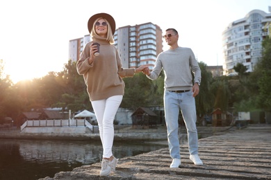 Couple in stylish sweaters on city pier