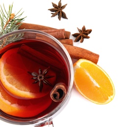 Photo of Glass cup of mulled wine, fresh orange and cinnamon sticks isolated on white
