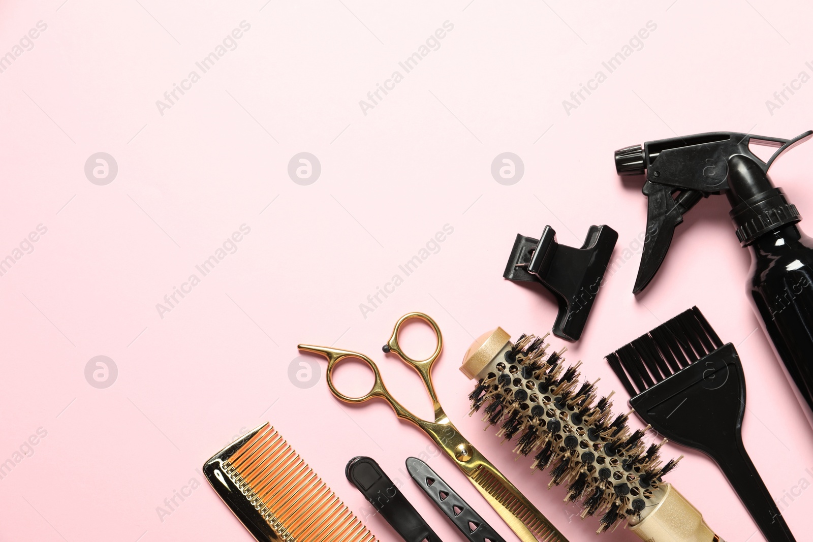 Photo of Professional hair dresser tools on pink background, flat lay. Space for text