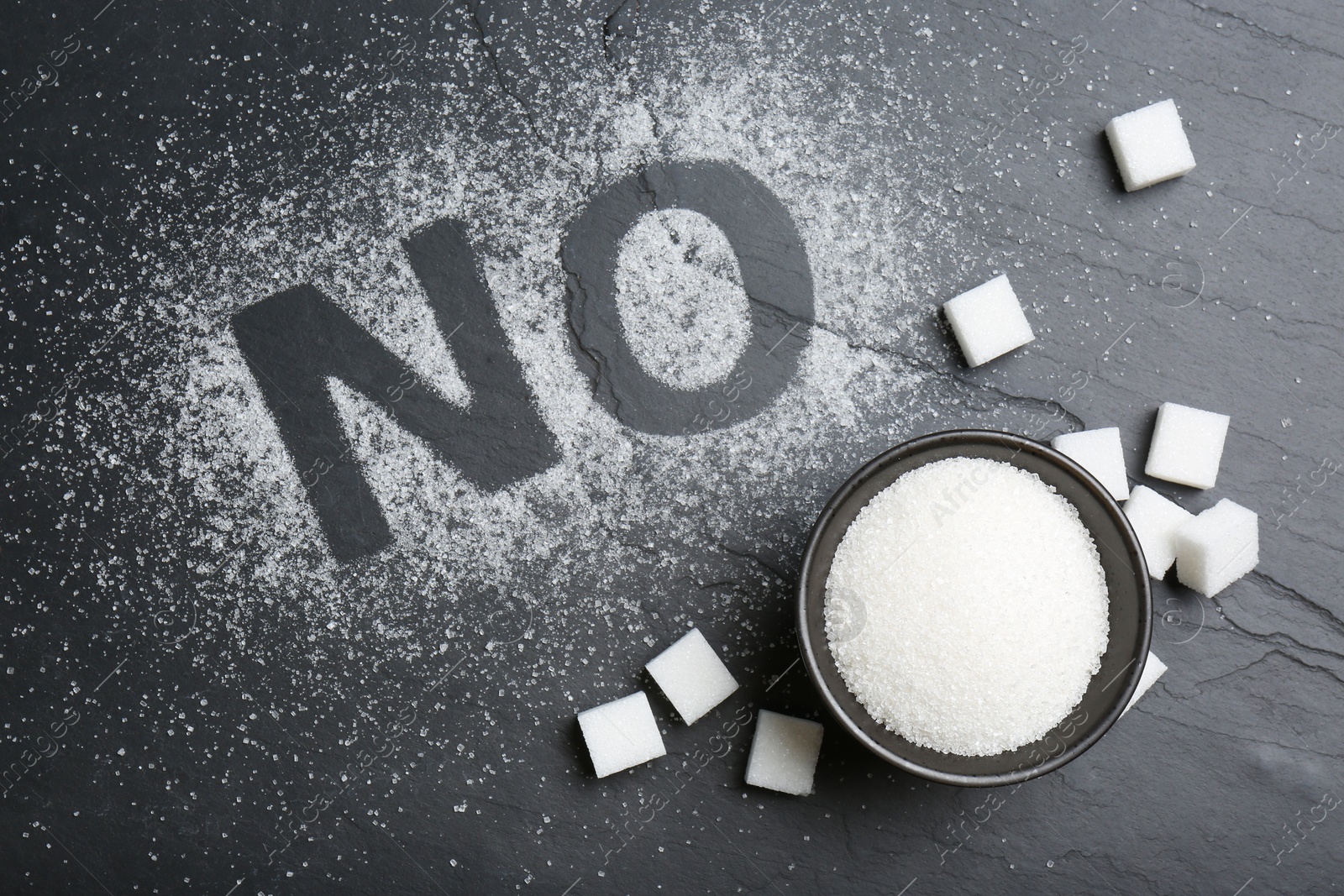 Photo of No sugar. Flat lay composition with refined cubes and granules on black table