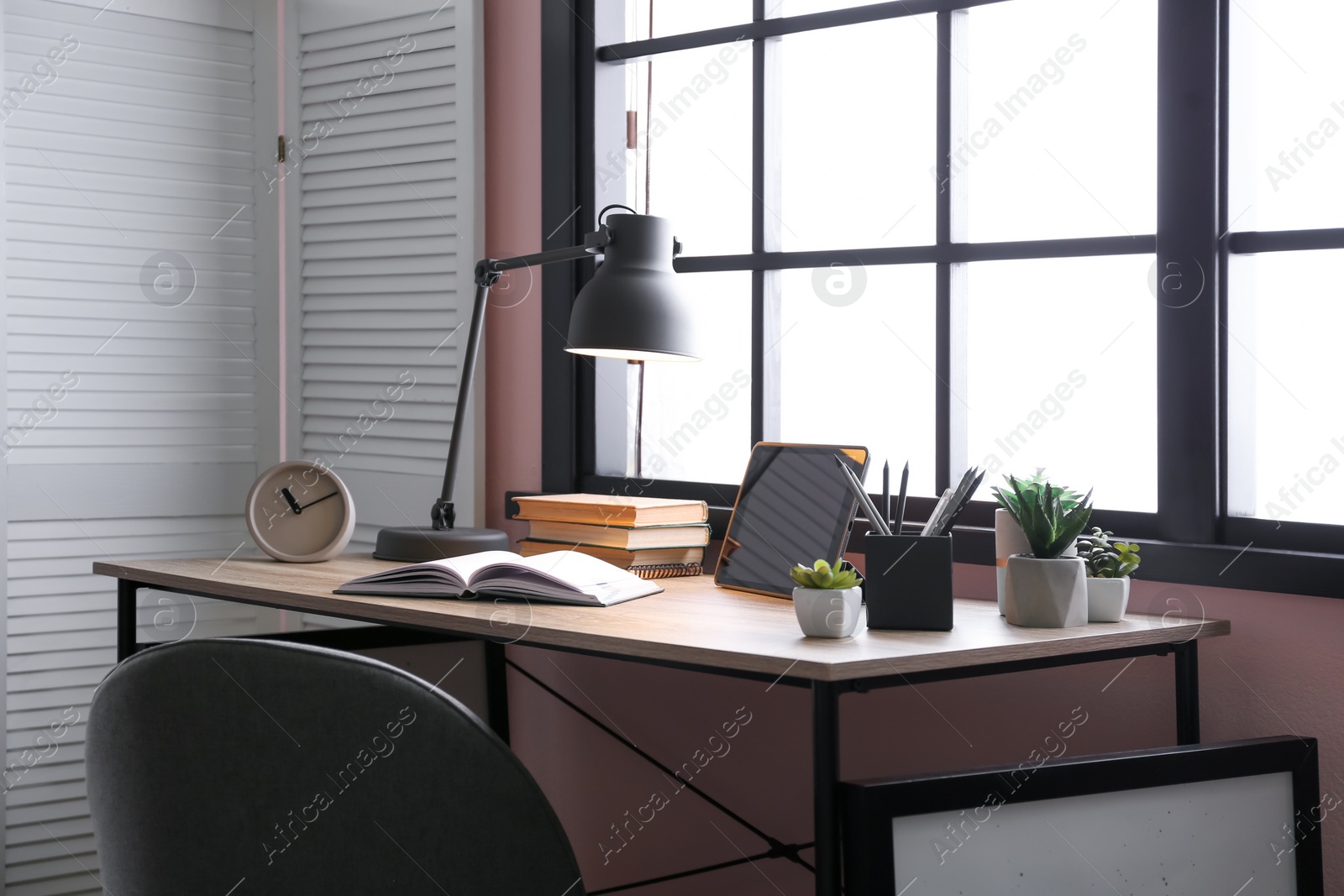 Photo of Stylish room interior with comfortable workplace near window