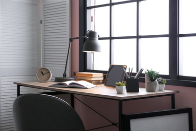 Stylish room interior with comfortable workplace near window