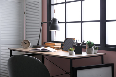 Photo of Stylish room interior with comfortable workplace near window