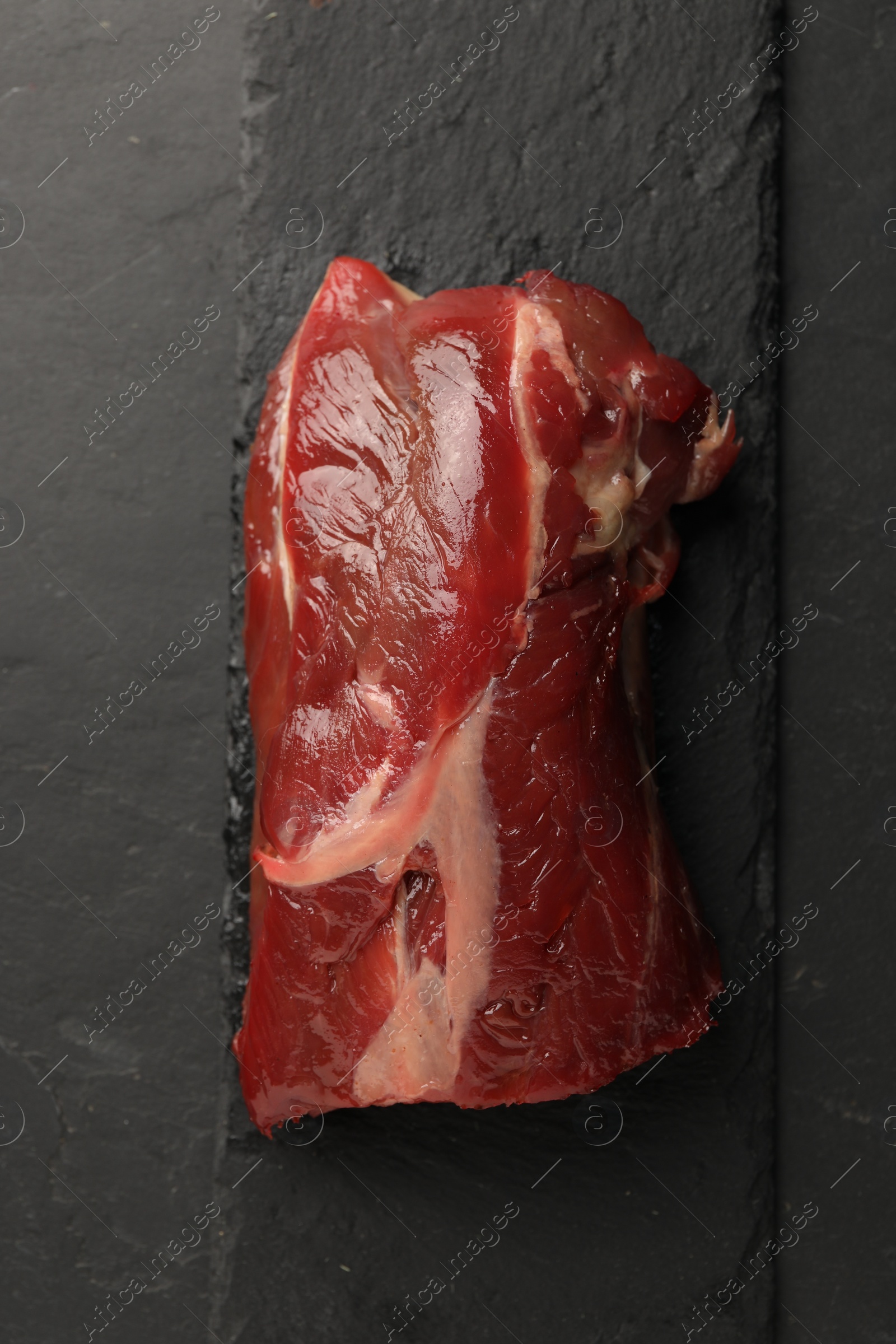 Photo of Piece of raw beef meat on black table, top view