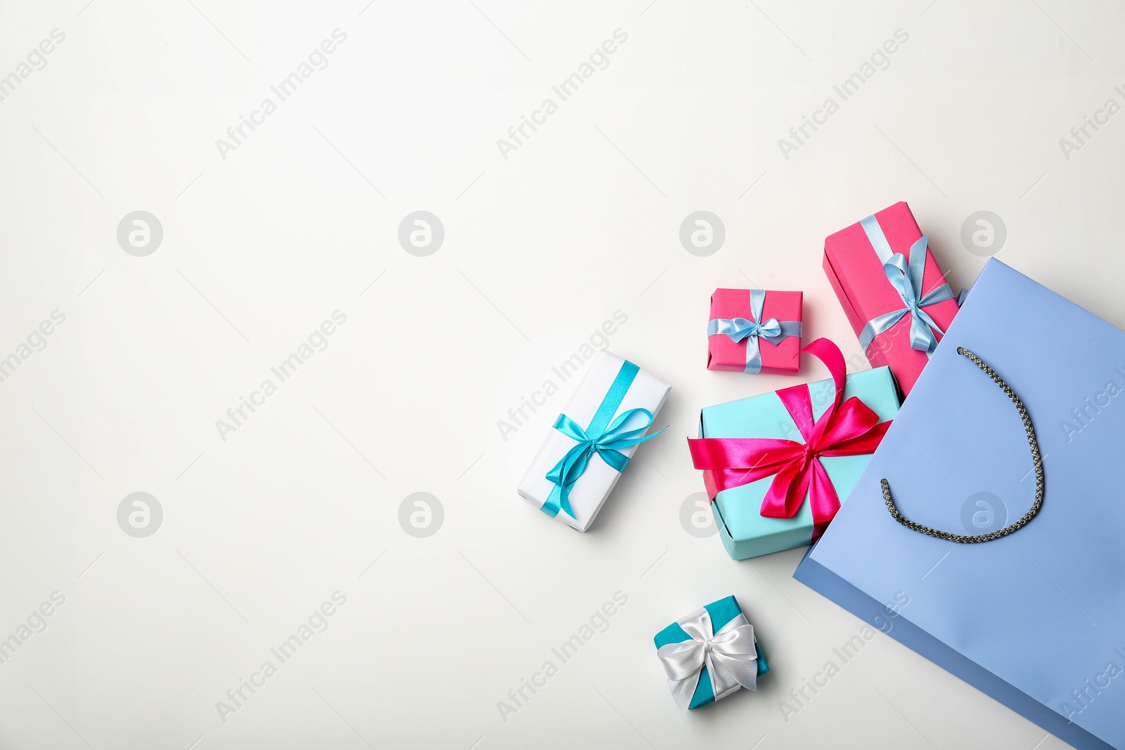 Photo of Flat lay composition with shopping bag and gifts on white background