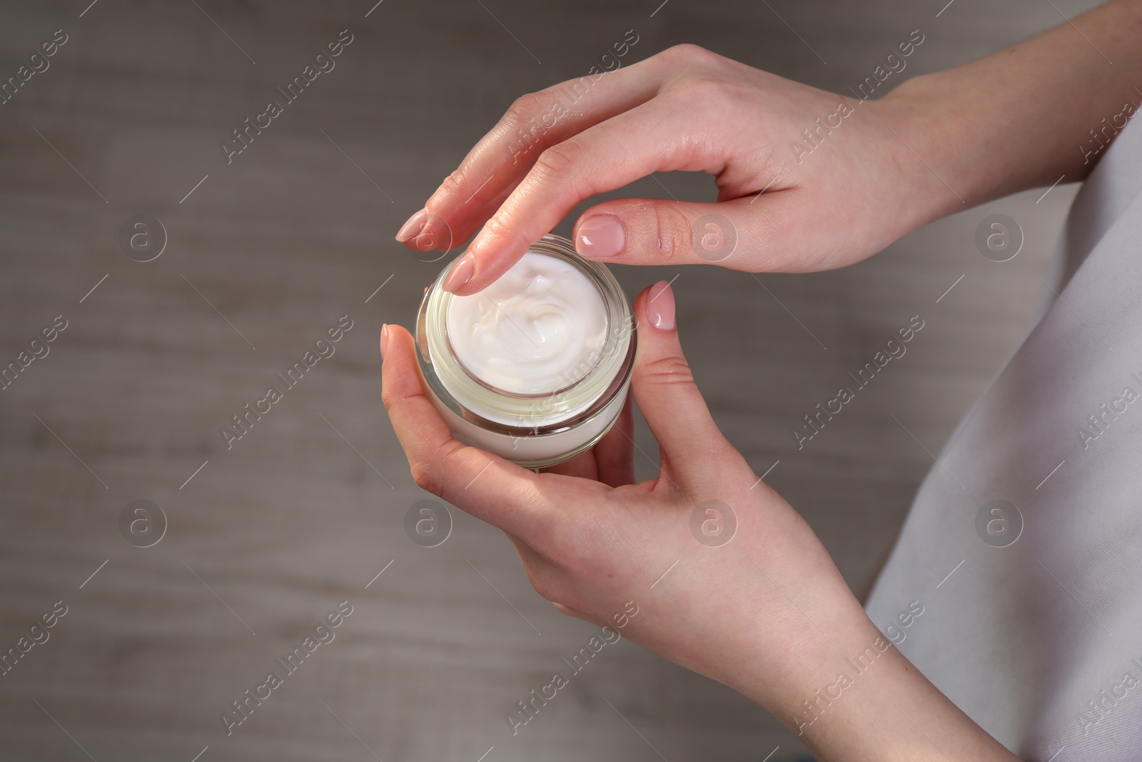 Photo of Woman applying hand cream indoors, above view