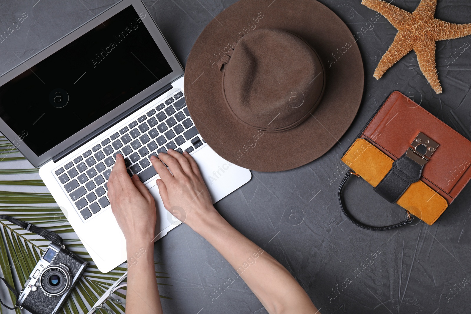 Photo of Blogger working with laptop at dark table, top view