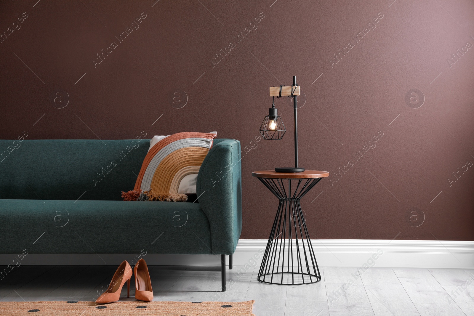 Photo of Stylish living room interior with comfortable sofa and lamp on coffee table