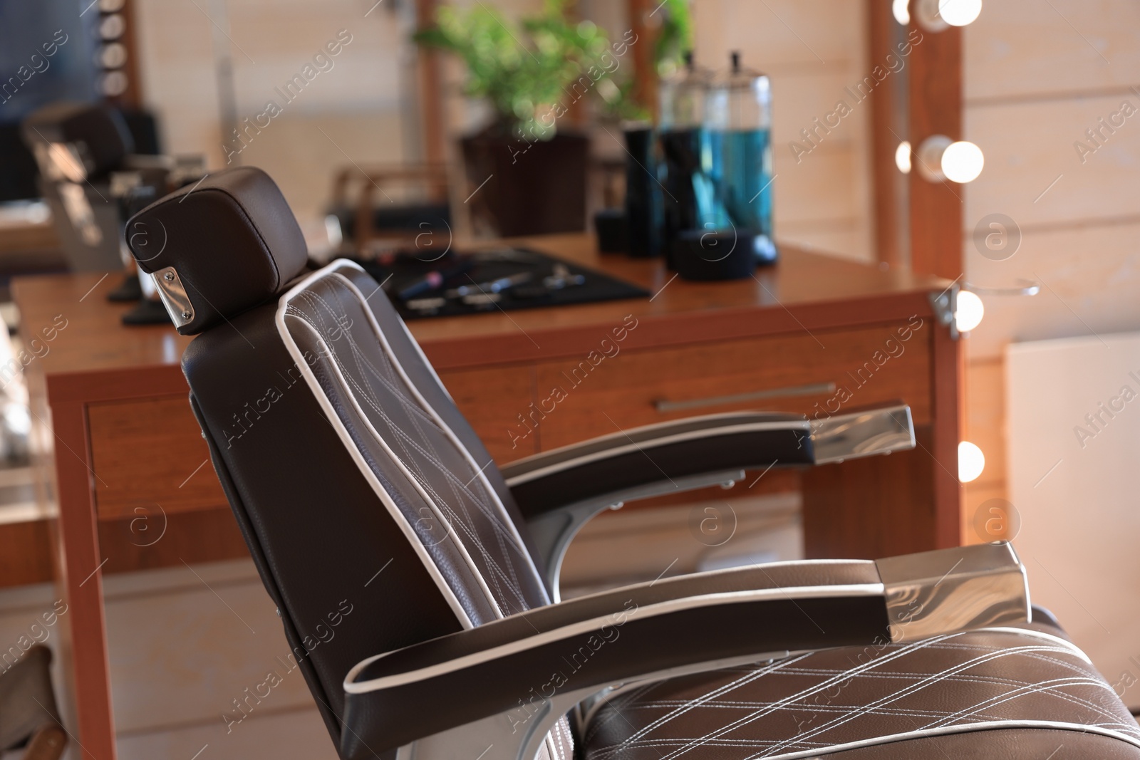 Photo of Stylish hairdresser's workplace with professional armchair in barbershop, closeup