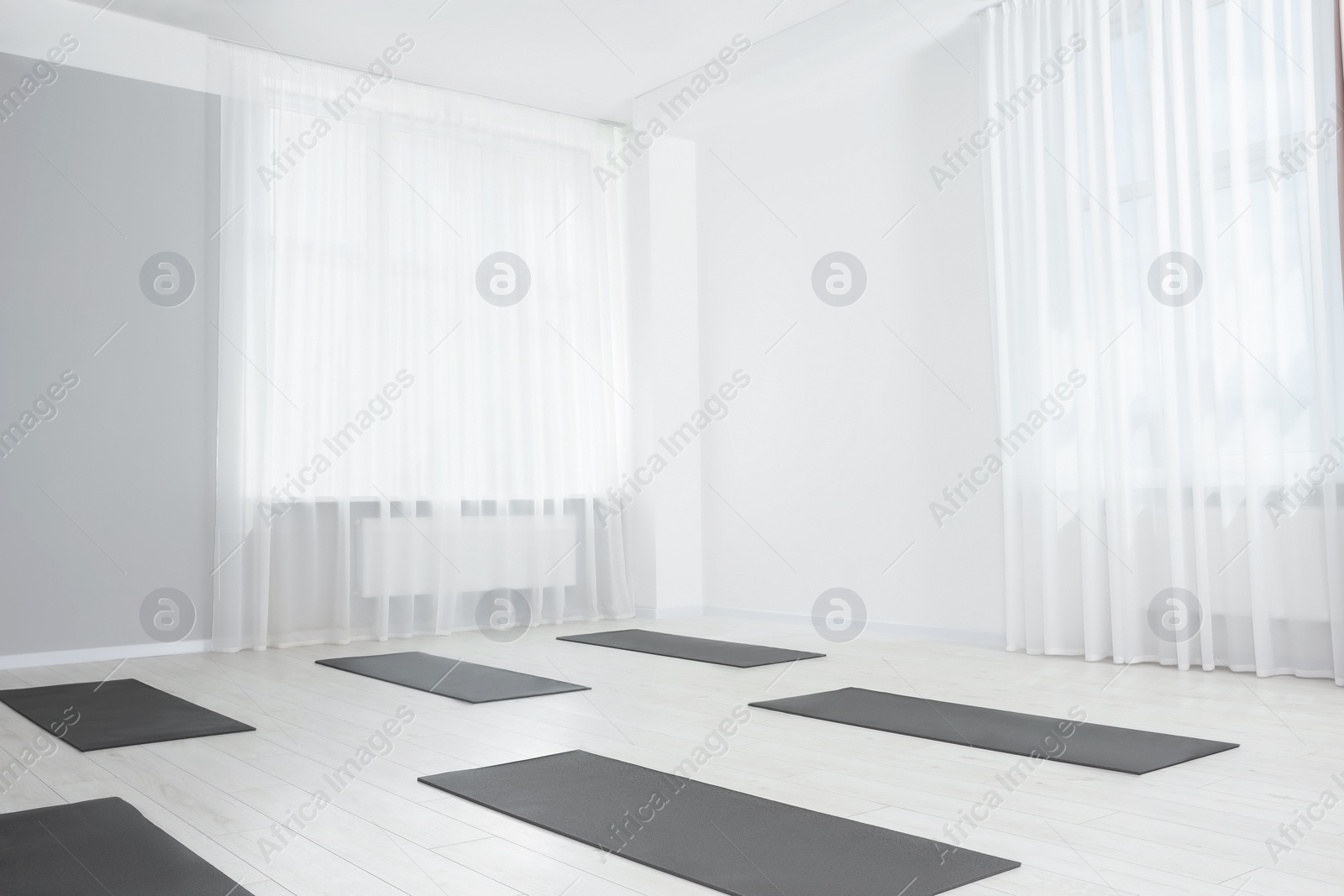 Photo of Spacious yoga studio with exercise mats. Space for text