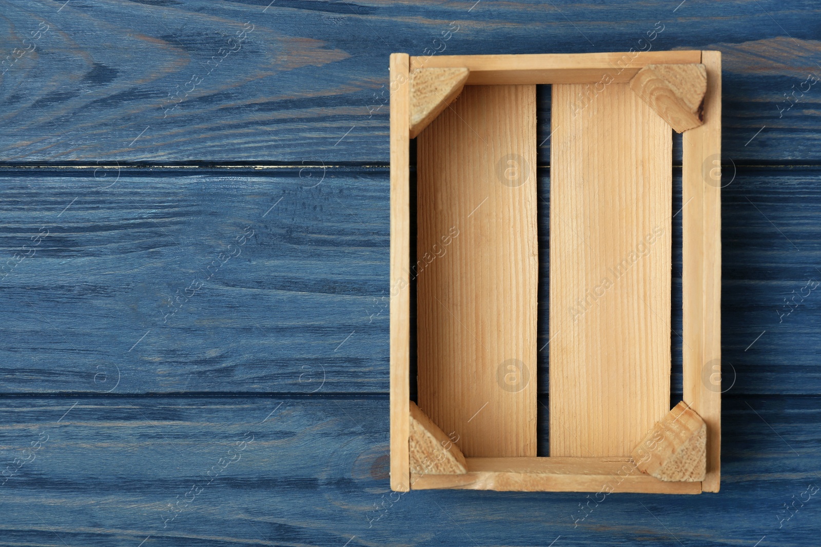 Photo of Empty wooden crate on color background, top view with space for text