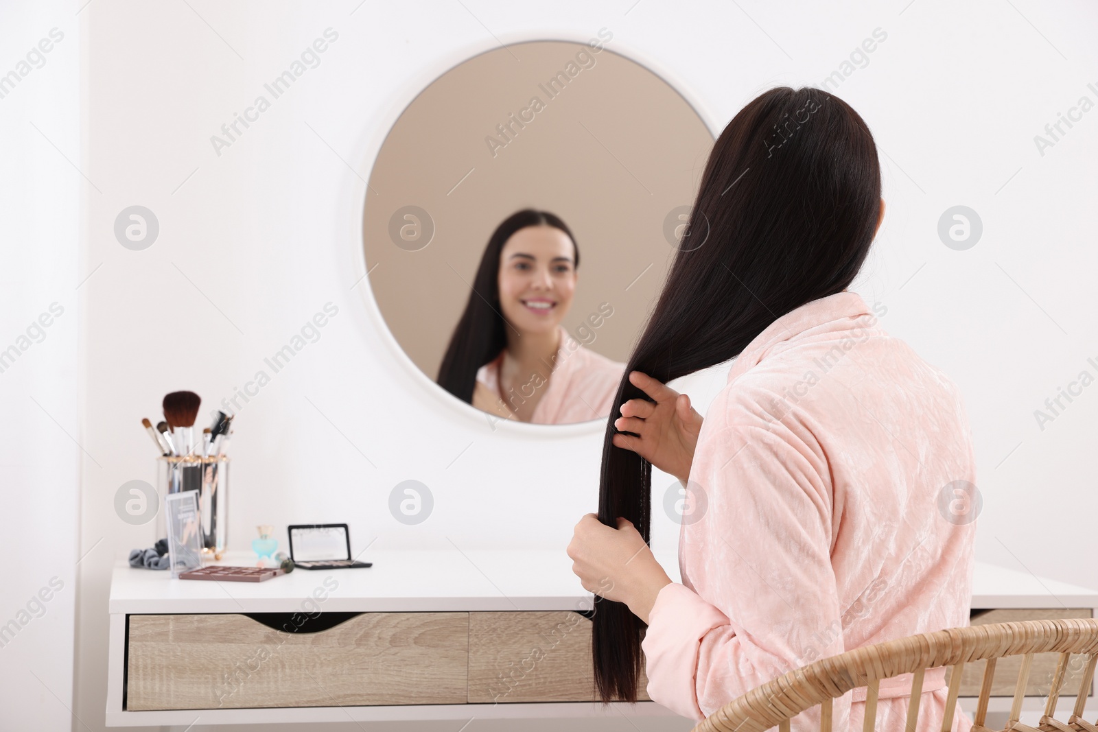 Photo of Beautiful young woman at dressing table indoors