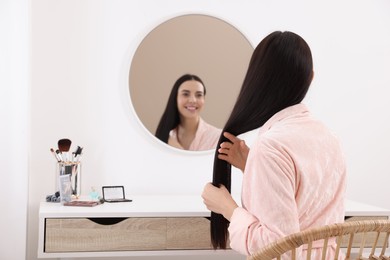 Photo of Beautiful young woman at dressing table indoors