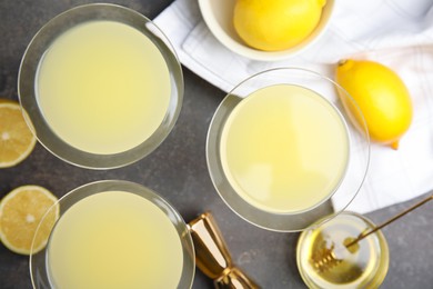 Photo of Delicious bee's knees cocktails and ingredients on grey table, flat lay