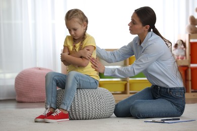 Photo of Child psychotherapist working with little girl in office