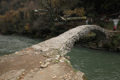 Adjara, Georgia - November 19, 2022: Picturesque view of stone arched bridge over Acharistskali river