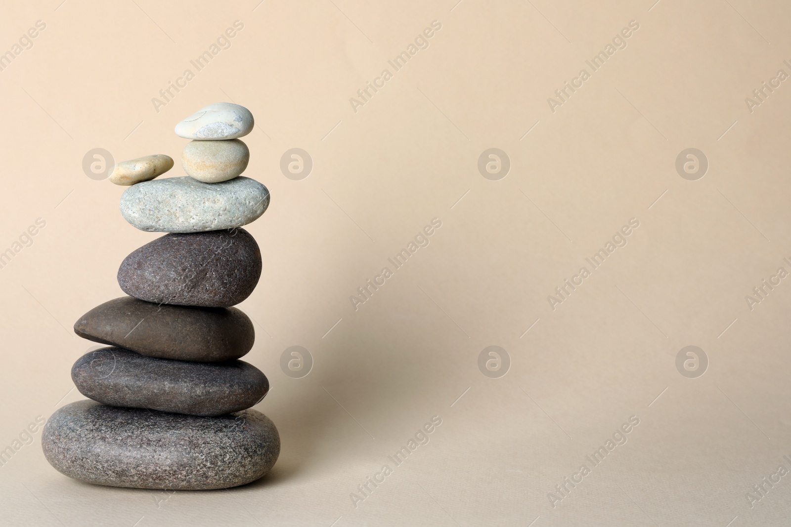 Photo of Stack of stones on beige background, space for text. Harmony and balance concept