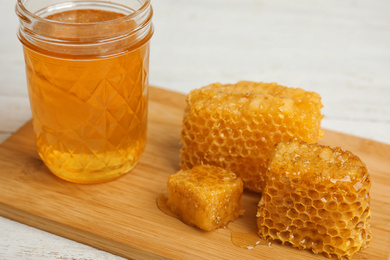 Photo of Composition with fresh honey on wooden board, closeup