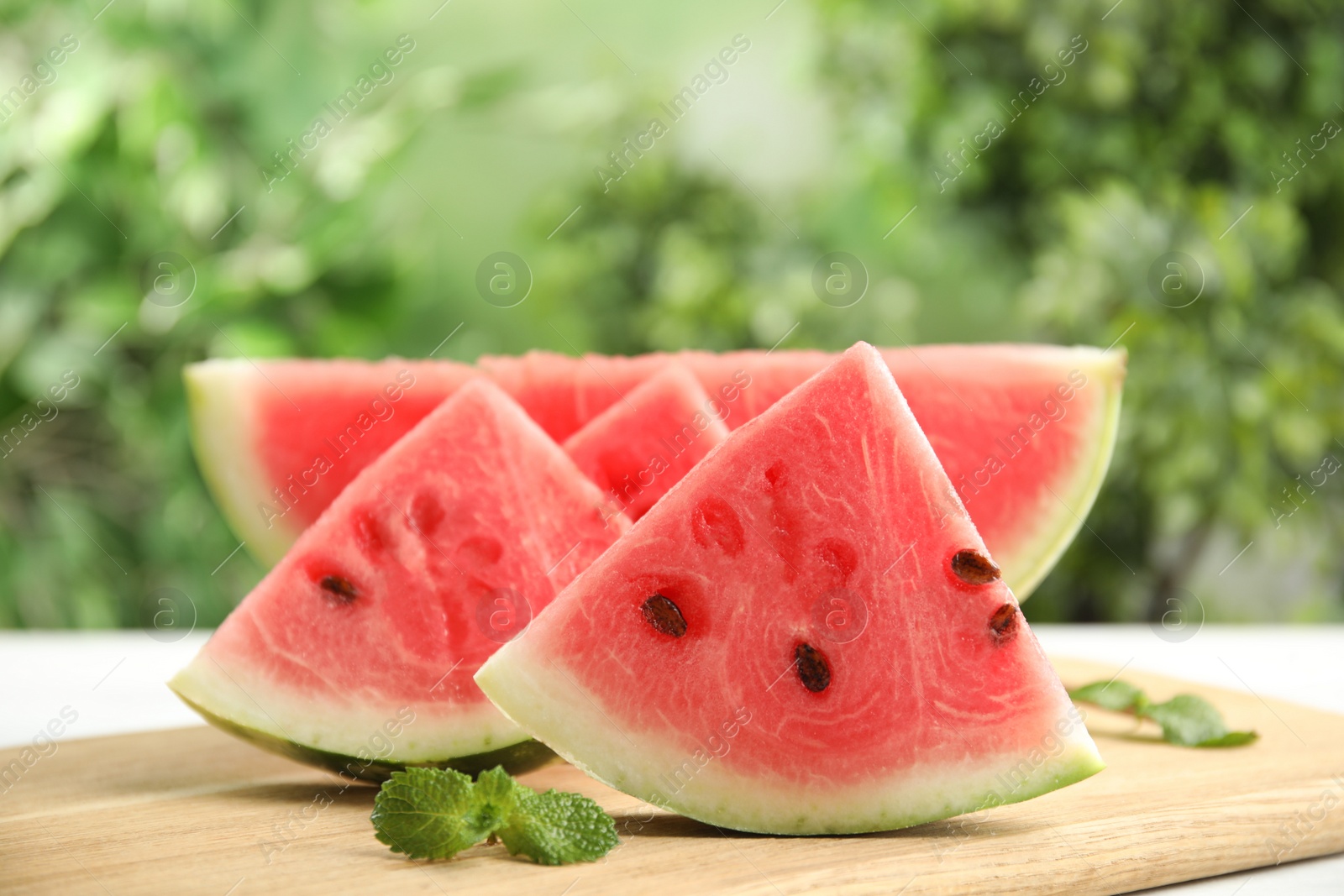 Photo of Slices of ripe juicy watermelon on wooden board