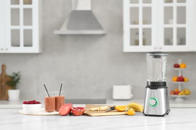 Photo of Blender, tasty smoothie and ingredients on white marble table in kitchen