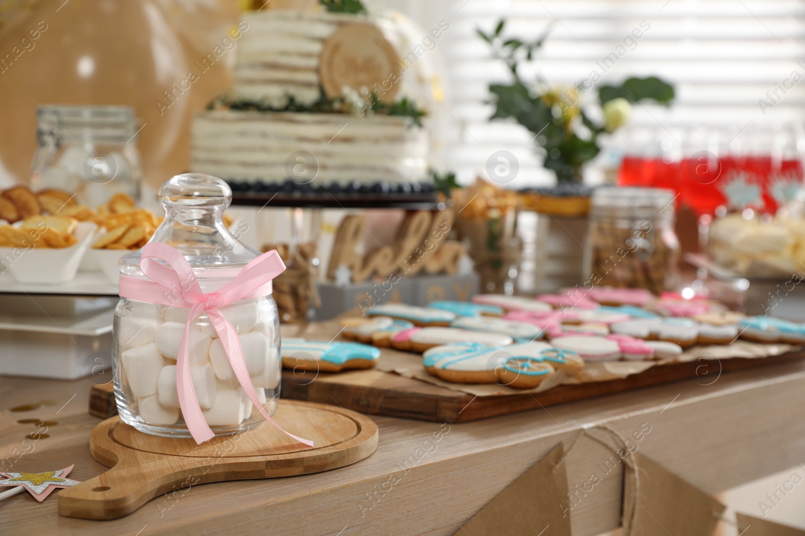 Photo of Baby shower party. Different delicious treats on wooden table indoors