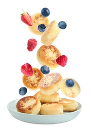 Image of Delicious cottage cheese pancakes and berries falling into plate on white background