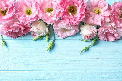 Photo of Flat lay composition with beautiful Eustoma flowers on wooden background