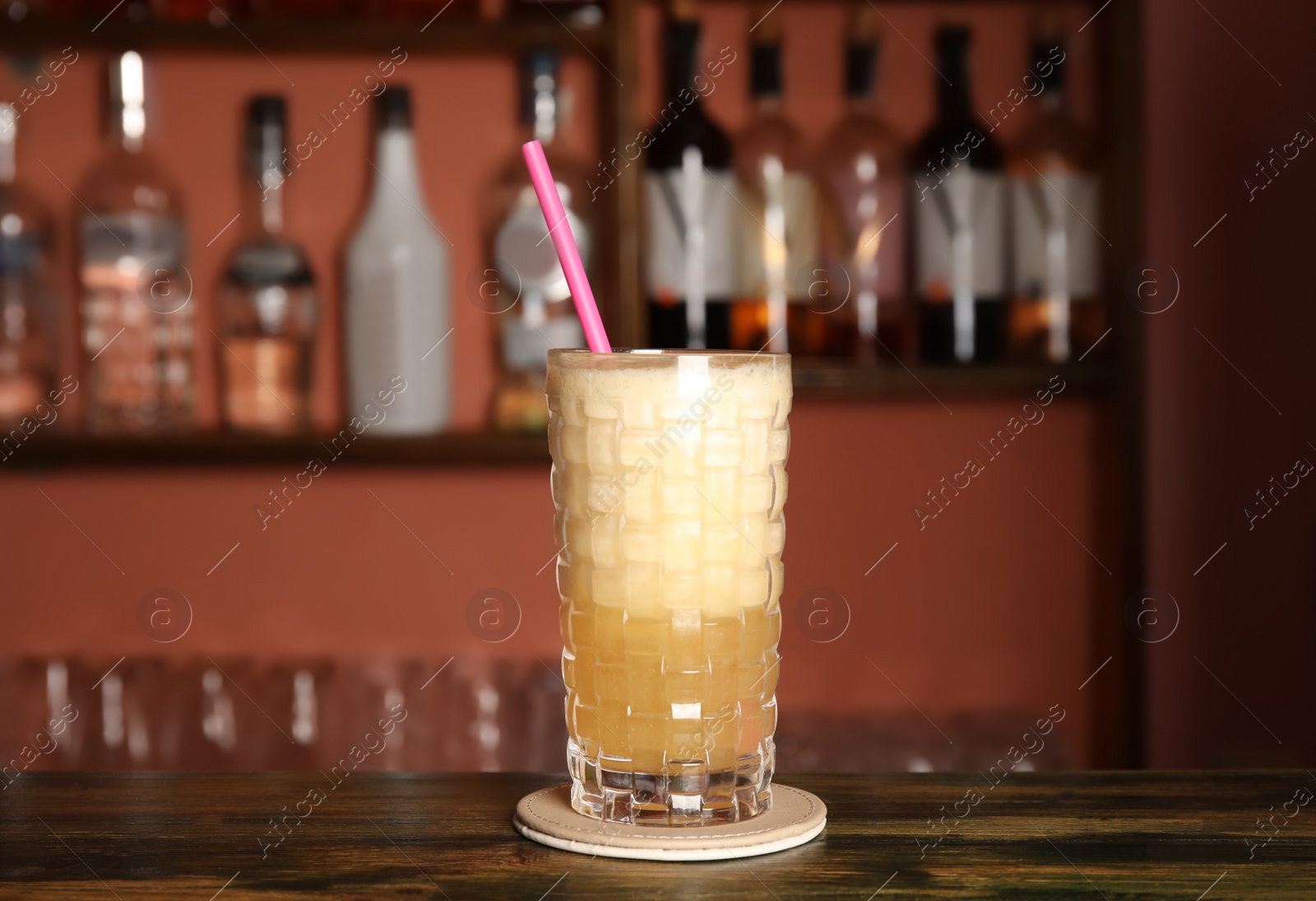 Photo of Glass with delicious cocktail on counter in bar