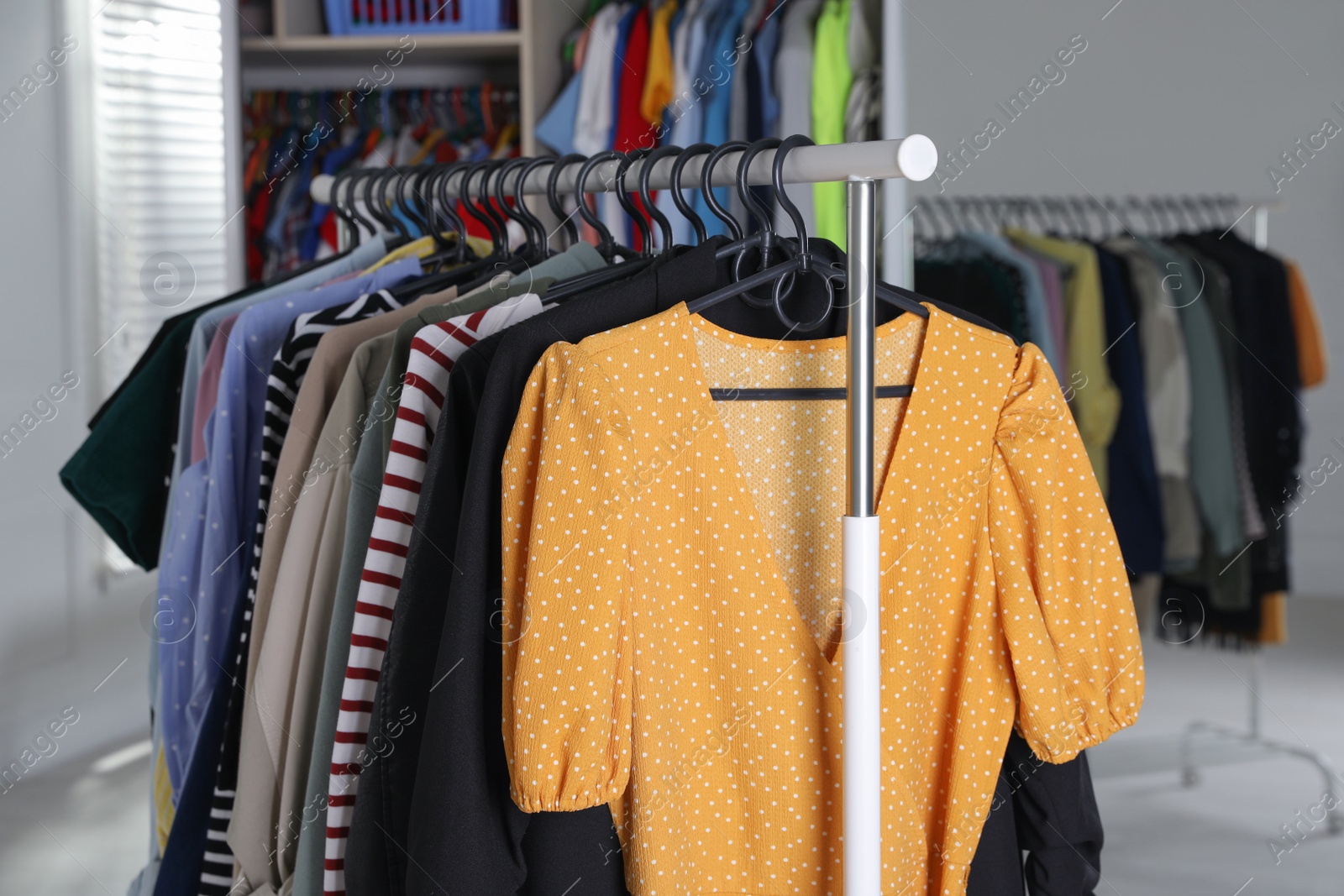 Photo of Rack with stylish women's clothes in dressing room