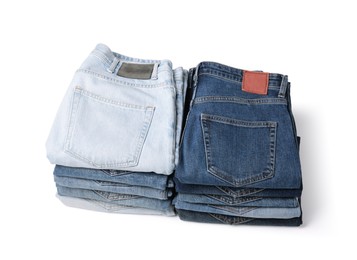 Stacks of different folded jeans isolated on white