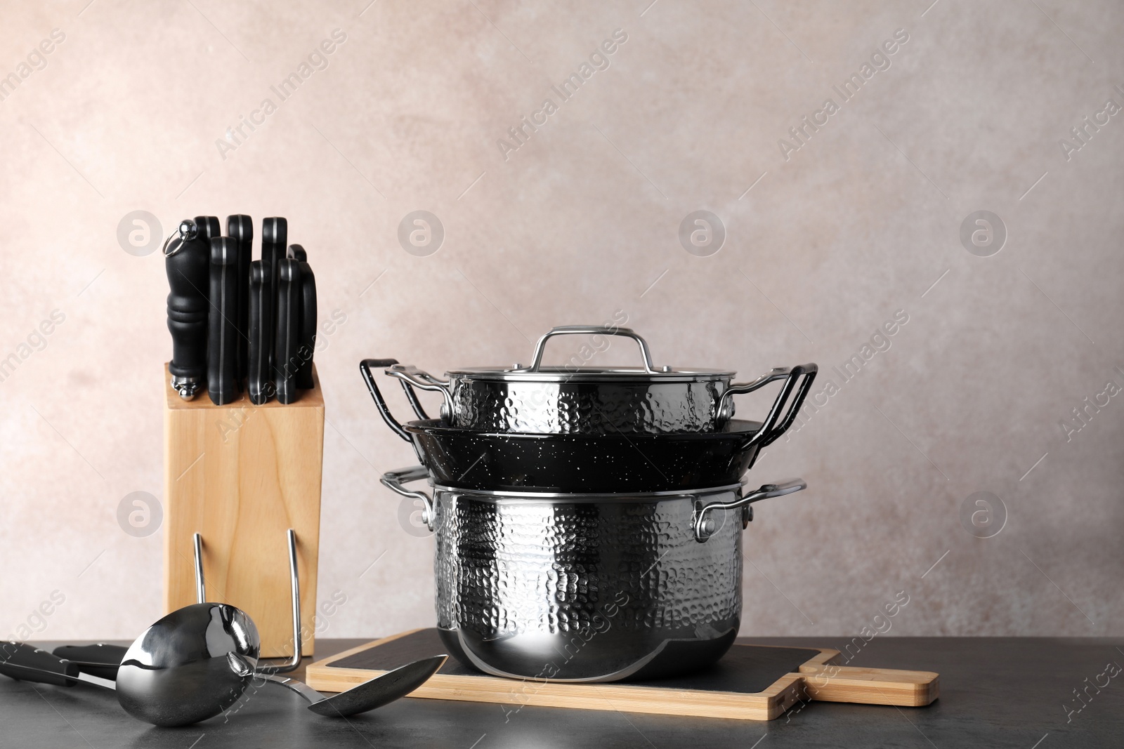 Photo of Set of clean cookware and utensils on table against color background. Space for text