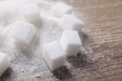 Different types of white sugar on wooden table, closeup. Space for text