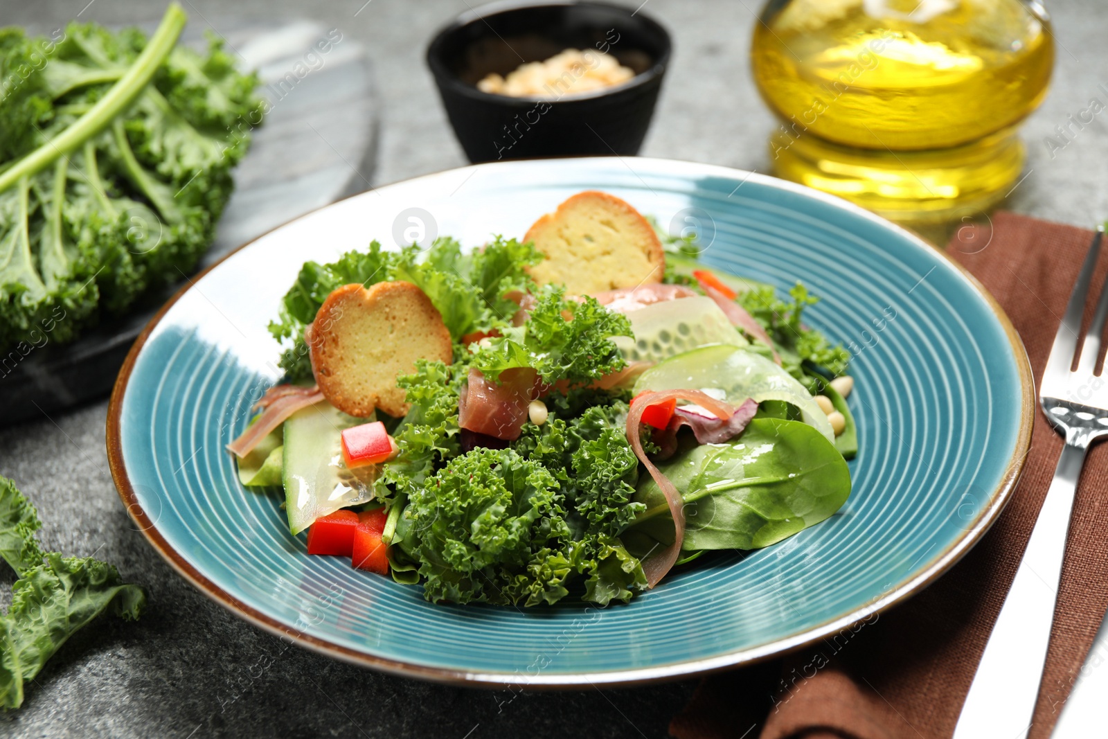 Photo of Delicious salad with kale leaves on table