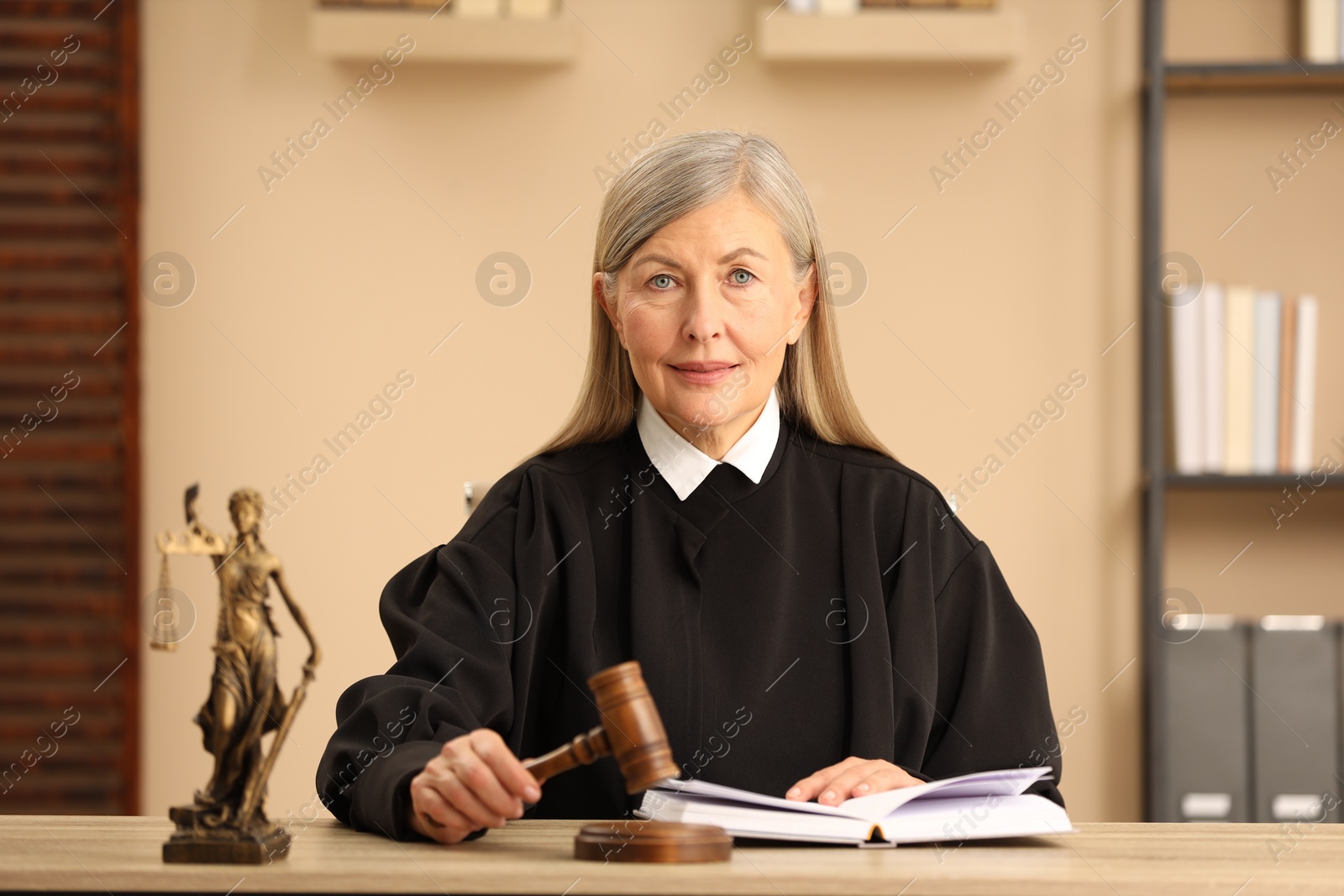 Photo of Judge striking mallet at wooden table indoors