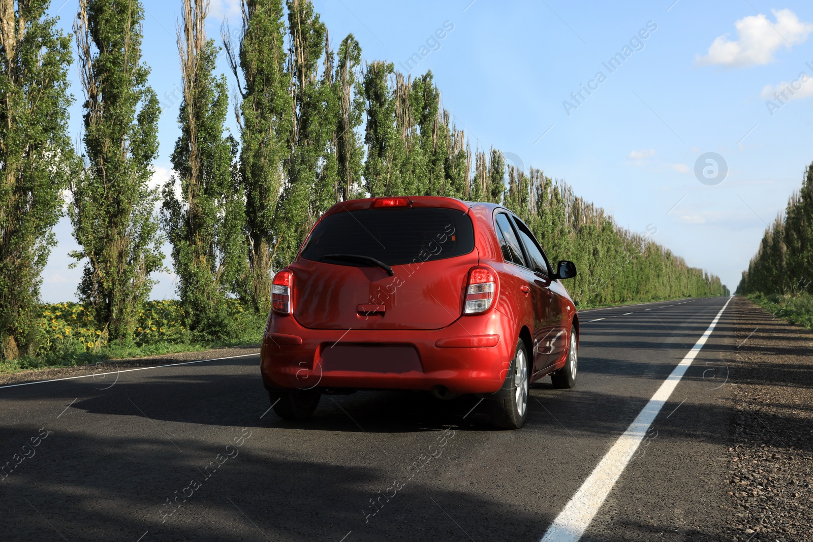 Photo of Red car on asphalt road in countryside