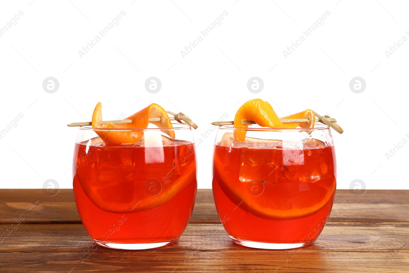 Photo of Aperol spritz cocktail and orange slices in glasses on wooden table against white background