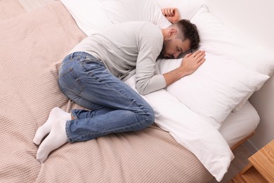 Photo of Upset man lying on bed. Loneliness concept