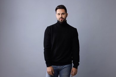 Photo of Handsome man in stylish black sweater on grey background
