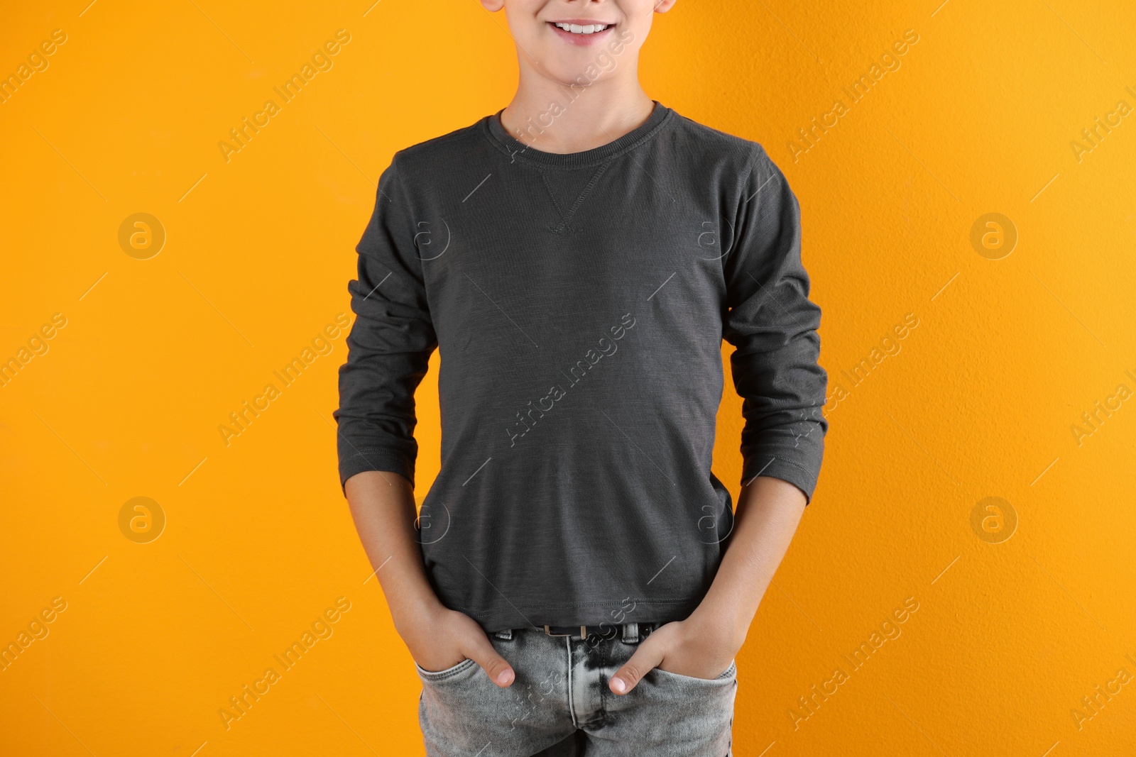 Photo of Little boy in long sleeve t-shirt on color background. Mock-up for design