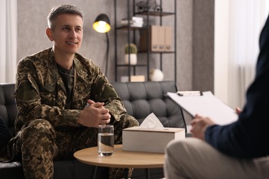 Photo of Professional psychotherapist working with military man in office